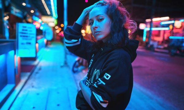 Neon close up portrait of young woman wear hoodie. night city street shot Neon close up portrait of young beautiful woman wear hoodie. night city street shot